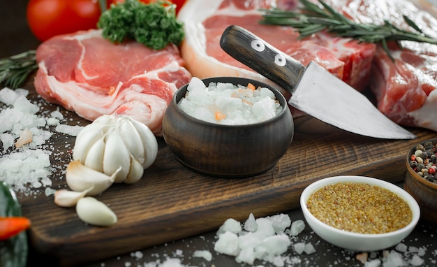 Carne cruda con spezie in una composizione con accessori da cucina