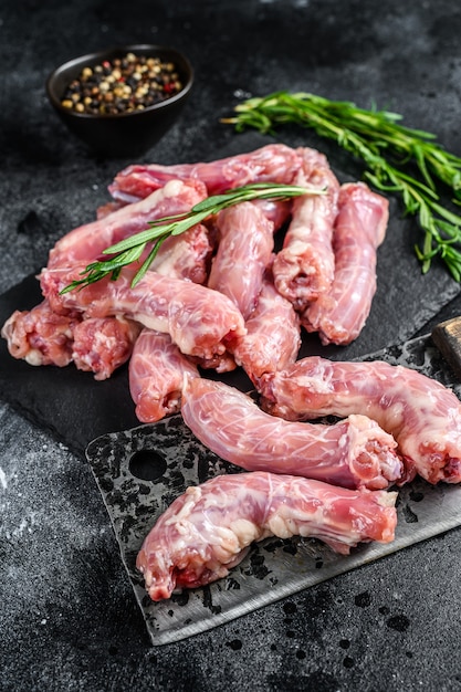 Carne cruda di collo di tacchino su un tagliere. Sfondo nero. Vista dall'alto.