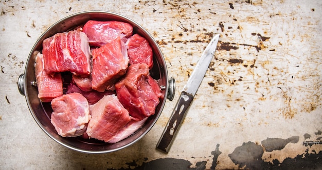 Carne cruda fresca tritata in un secchio con un coltello