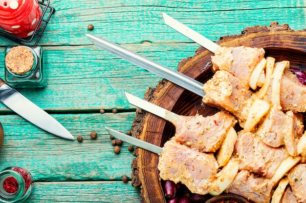 Carne cruda in una marinata barbecue su spiedini.Spiedini di carne cruda per un picnic.