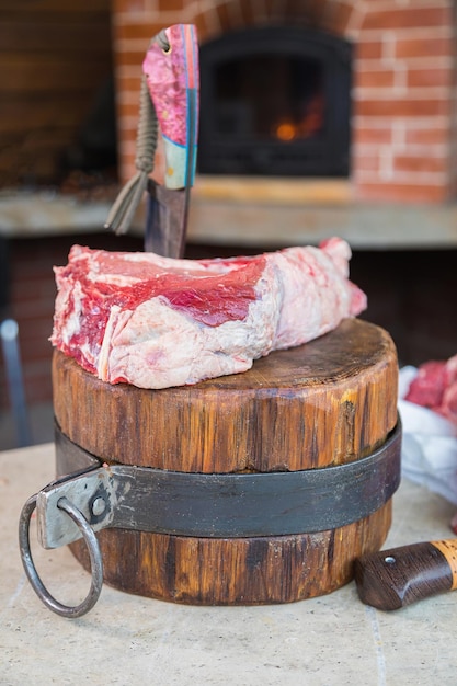 Carne cruda su un ponte un coltello incastrato nella carne carne fresca su un tavolo da taglio