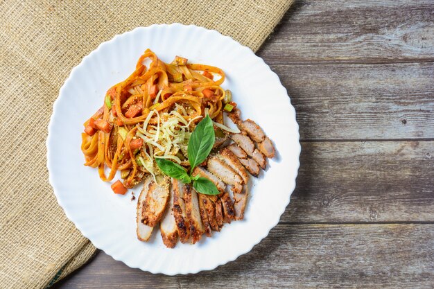 Carne della bistecca con spaghetti e formaggio su legno