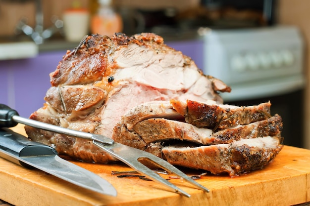 Carne di maiale al forno con spezie sul tagliere di legno marrone