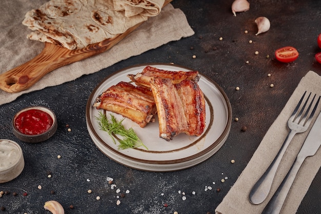 Carne di maiale alla griglia barbecue, con texture di sfondo scuro