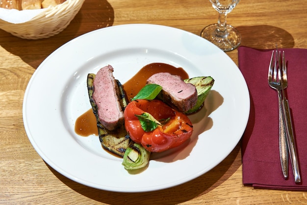 Carne di maiale alla griglia con verdure, peperoni e melanzane sul tavolo