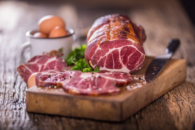 Carne di maiale. Braciola di maiale affumicata. Carne affumicata tradizionale su tavola di legno di quercia in altre posizioni.