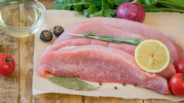 Carne di maiale cruda affettata con le spezie su una tavola rustica.