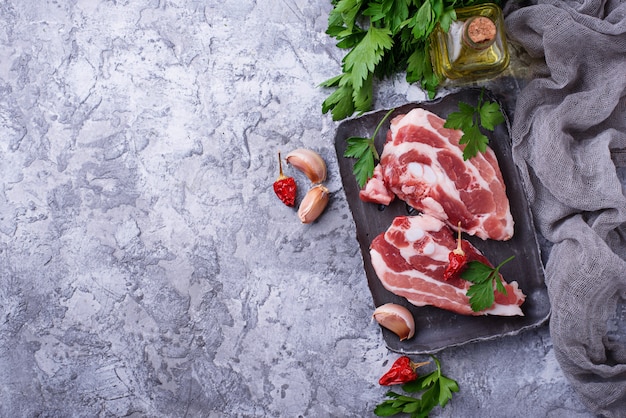 Carne di maiale cruda e ingredienti per cucinare. Vista dall&#39;alto
