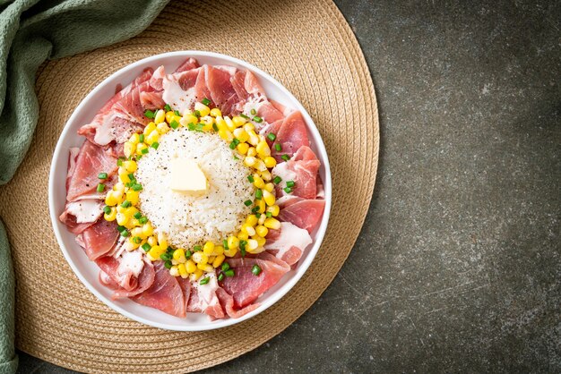 carne di maiale fresca cruda affettata con riso e mais su piatto bianco e pronta da cucinare