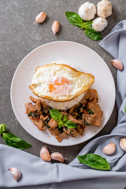 carne di maiale saltata in padella con basilico su riso e uovo fritto