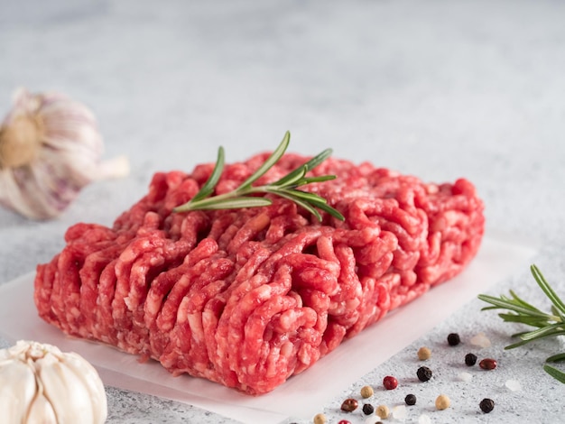 Carne di manzo macinata cruda su fondo di cemento grigio chiaro