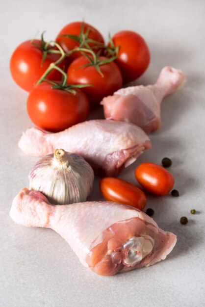 Carne di pollo fresca su sfondo grigio Pomodori crudi Pepe Ingredienti per una cena sana verticale