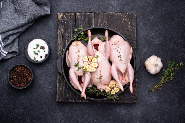 Carne di quaglia cruda con spezie, aglio ed erbe aromatiche pronte per la cottura