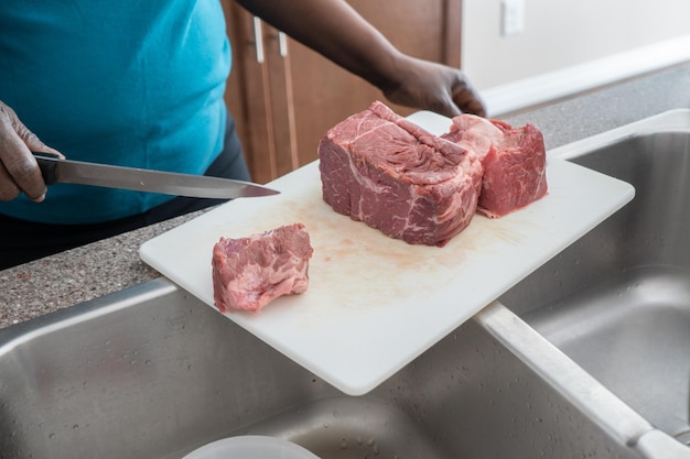 Carne di taglio della donna afroamericana nigeriana sul tagliere