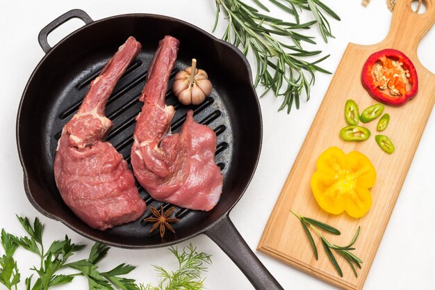 Carne di vitello con osso in padella e peperoni colorati a pezzetti sul tagliere