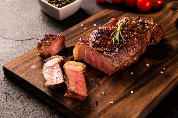 Carne fresca alla griglia. Bistecca di manzo alla griglia mediamente cotta su tavola di legno. Vista dall'alto.