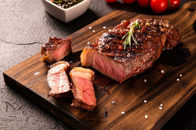 Carne fresca alla griglia. Bistecca di manzo alla griglia mediamente cotta su tavola di legno. Vista dall'alto.