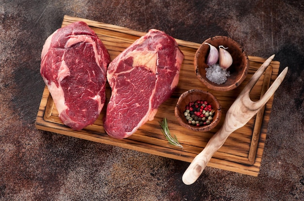 Carne fresca cruda Ribeye Steak a forma di cuore su una tavola di legno