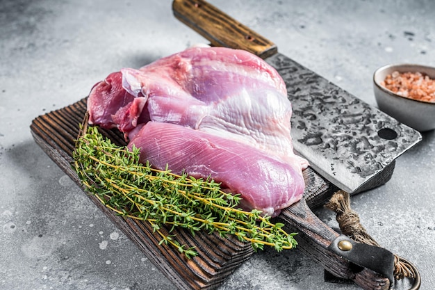 Carne fresca di pollame Filetto di coscia di tacchino crudo su tagliere di legno Sfondo grigio Vista dall'alto