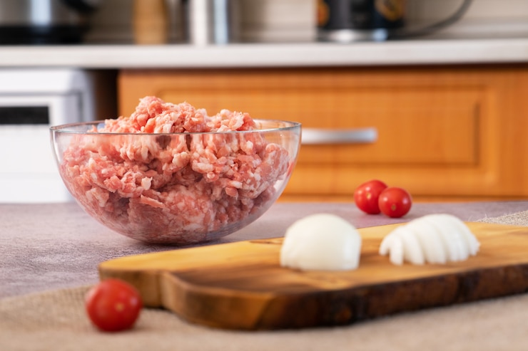 Carne fresca e macinata in un piatto sul tavolo in cucina.