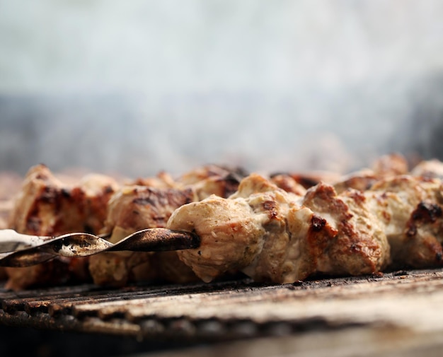 Carne fresca su uno spiedino d'acciaio in un braciere