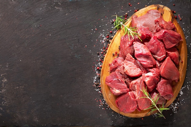 Carne fresca tritata con rosmarino su tavola di legno