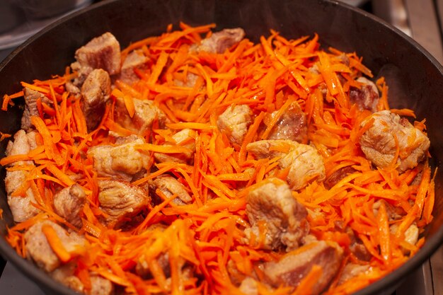 Carne fritta con carote in padella. Foto di alta qualità