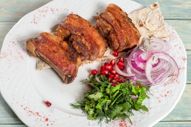 Carne fritta con cipolla, verdure e melograno