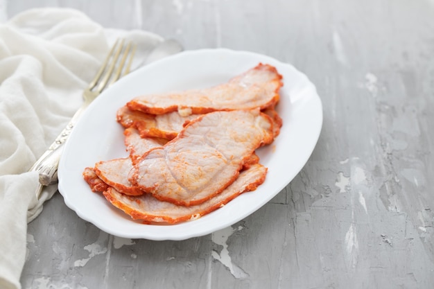 Carne fritta sul piatto bianco su fondo in ceramica