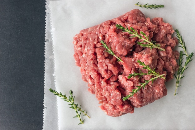 Carne macinata cruda con timo e spezie per cucinare cotolette.