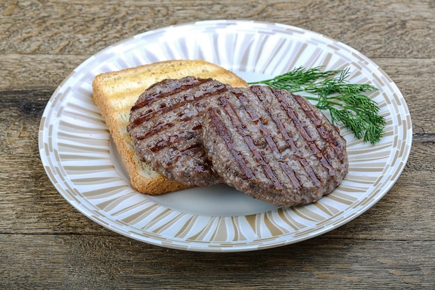Carne macinata di manzo alla griglia con cotoletta di hamburger su sfondo di legno