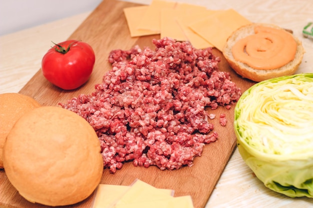 Carne macinata fresca per fare un hamburger in casa. Ingredienti per un cheeseburger fatto in casa.