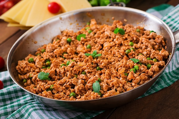 Carne macinata in una padella per farcire le lasagne.