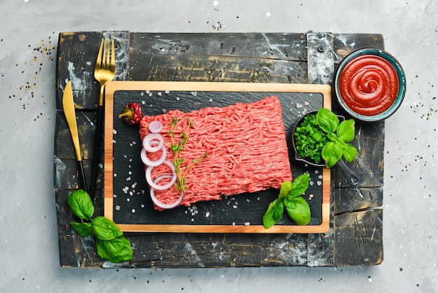 Carne Manzo macinato fresco su un piatto Preparazione delle cotolette Vista dall'alto Su uno sfondo di pietra