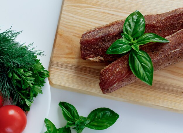 Carne su una tavola di legno con verdure