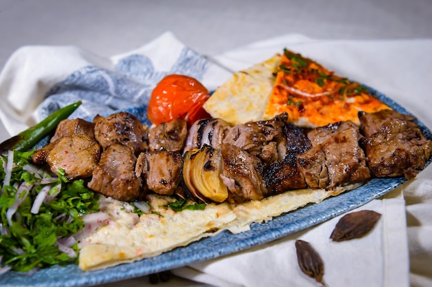 carne tikka boti seekh kabab di pollo montone manzo agnello con pane pita pomodoro e cipolla serviti in un piatto isolato sul tavolo alimentare vista dall'alto delle spezie del Medio Oriente
