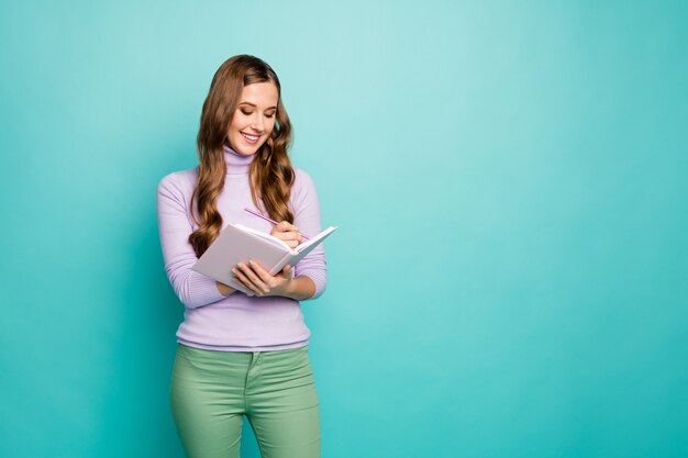 Caro diario. Foto di bella signora ondulata tenere planner scrivere segreti privati nel diario ispirazione momento indossare maglione lilla verde pastello pantaloni isolati colore verde acqua