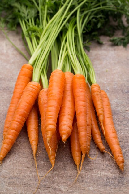 Carota fresca e dolce su un tavolo di legno grigio