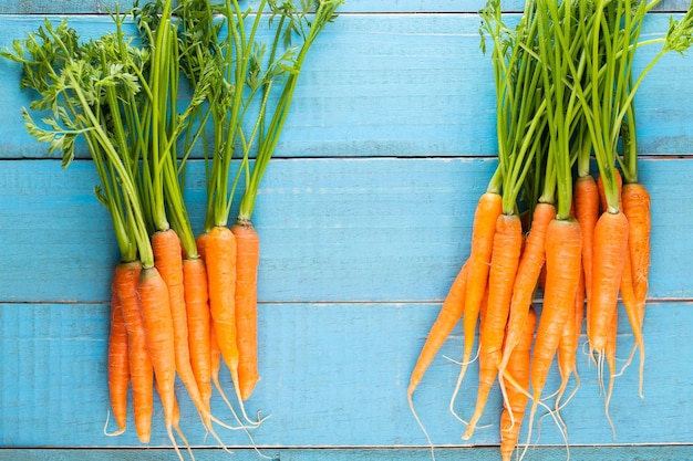 Carota fresca e dolce su un tavolo di legno grigio