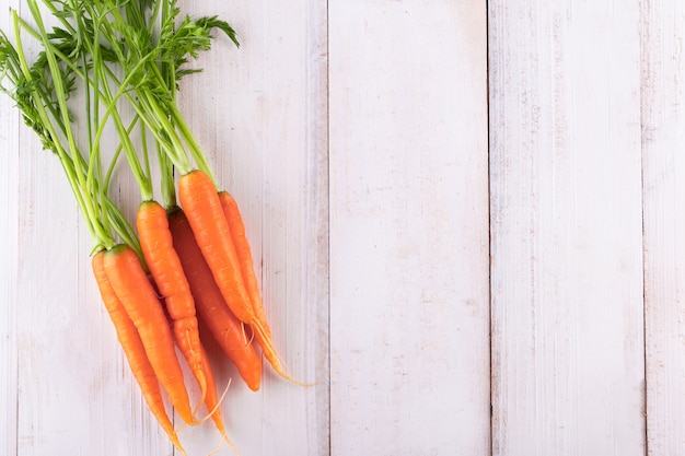 Carota fresca e dolce su un tavolo di legno grigio