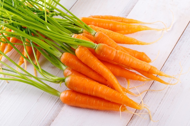 Carota fresca e dolce su un tavolo di legno grigio