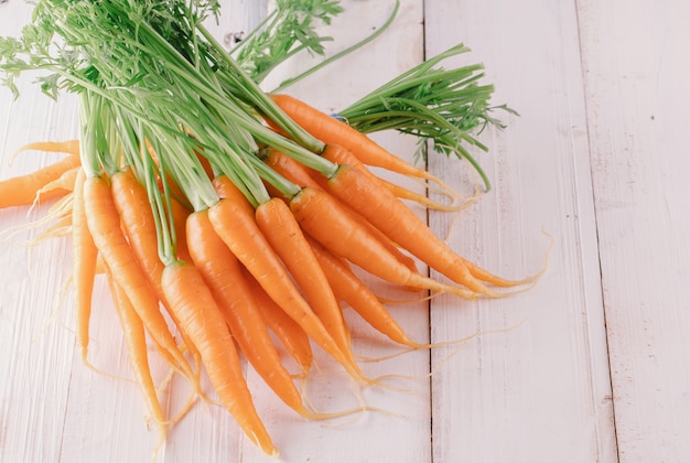 Carota fresca e dolce su una tavola di legno grigia