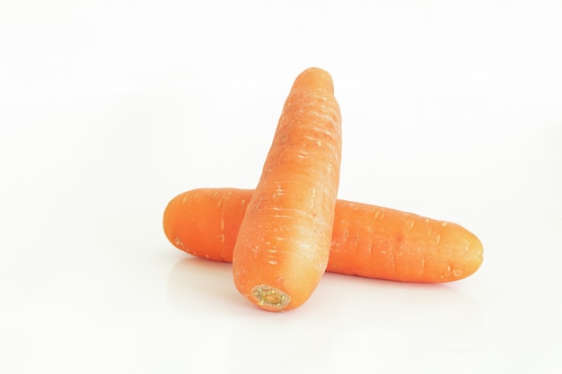 Carota fresca e pezzi tagliati isolati su bianco