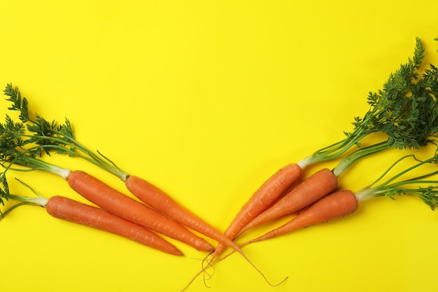 Carota fresca su sfondo giallo, spazio per il testo