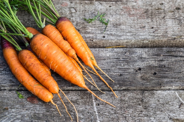 Carota su un vecchio tavolo di legno.