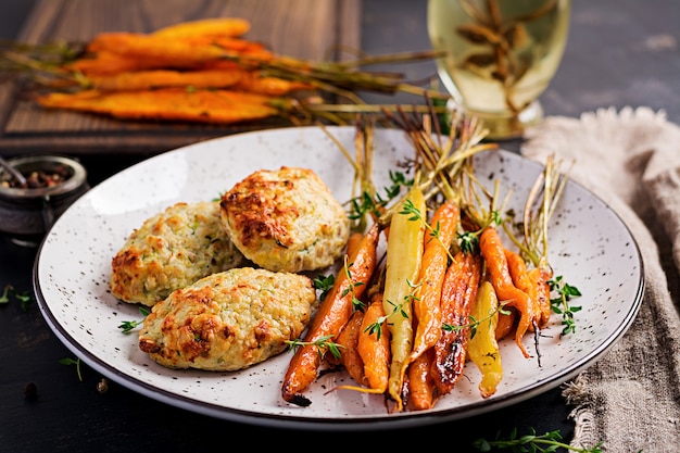 Carote biologiche al forno con timo e cotoletta / polpetta di pollo e zucchine. Dieta alimentare.