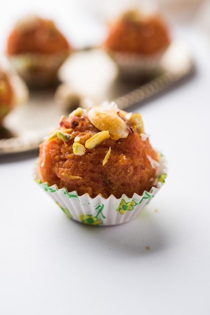 Carote Halwa Laddu o palline dolci, servite in un piatto con guarnizioni di frutta secca. messa a fuoco selettiva