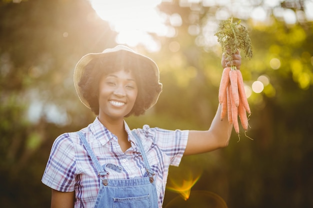 Carote sorridenti della tenuta della donna nel giardino