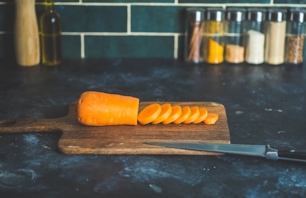 Carote sul tavolo della cucina prima della cottura. Cibo sano fatto in casa, ricette vegetariane e fatte in casa