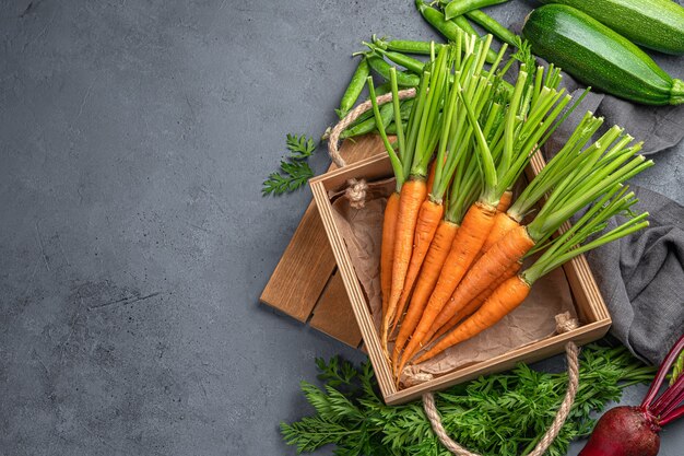 Carote, zucchine e barbabietole crude su sfondo grigio. Vista dall'alto, copia dello spazio. Prodotti naturali e biologici.